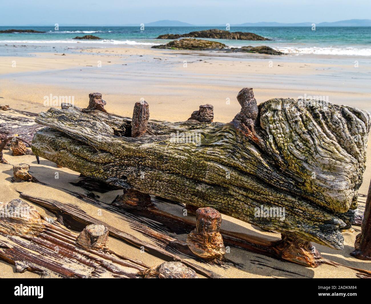 Detail of old shipwrecked wooden ship's timbers and nails buried in the sand of Balnahard beach, Isle of Colonsay in the Inner Hebrides, Scotland, UK Stock Photo