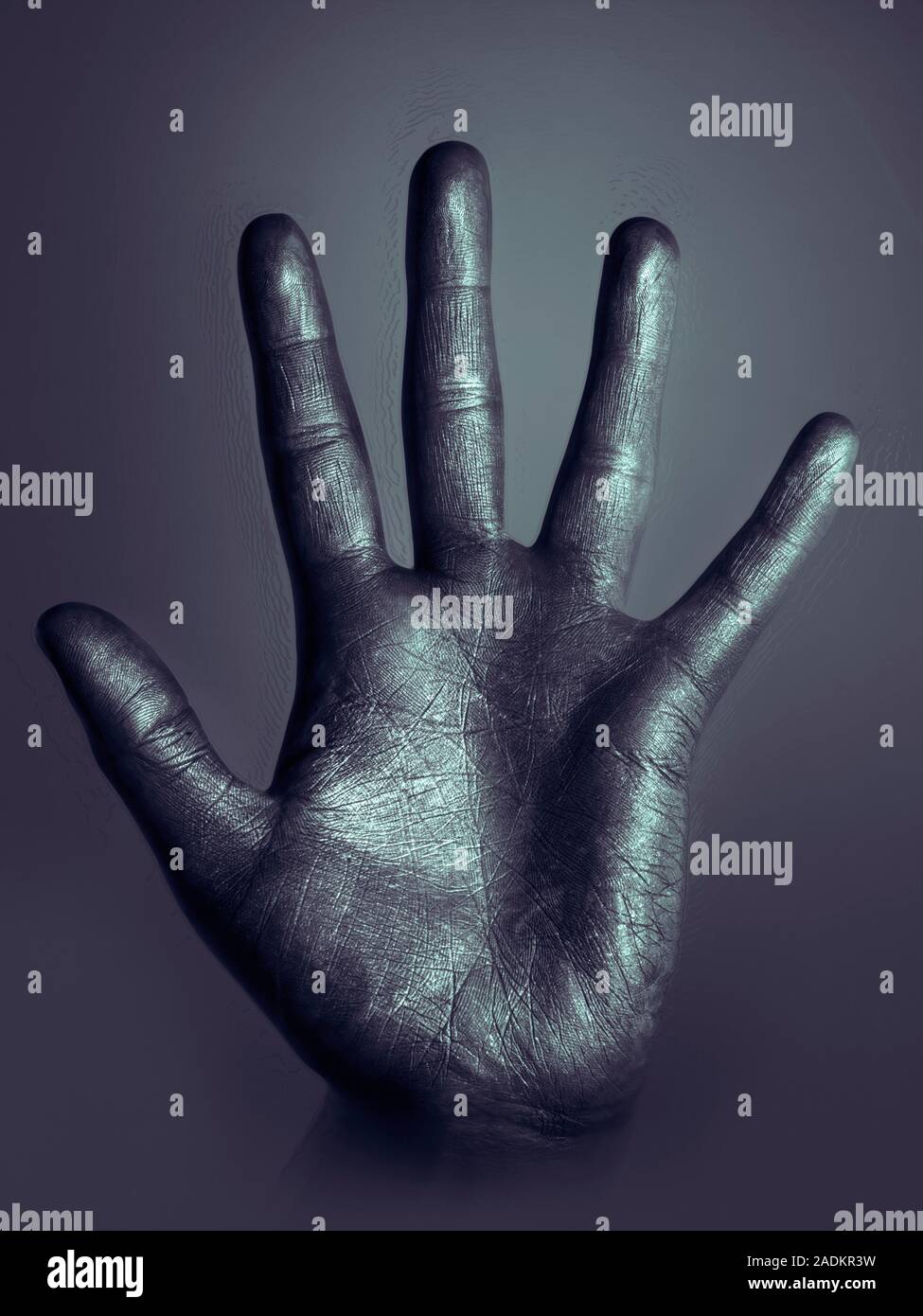 Hand pressed against glass. Palm and fingers of a male hand pressed
