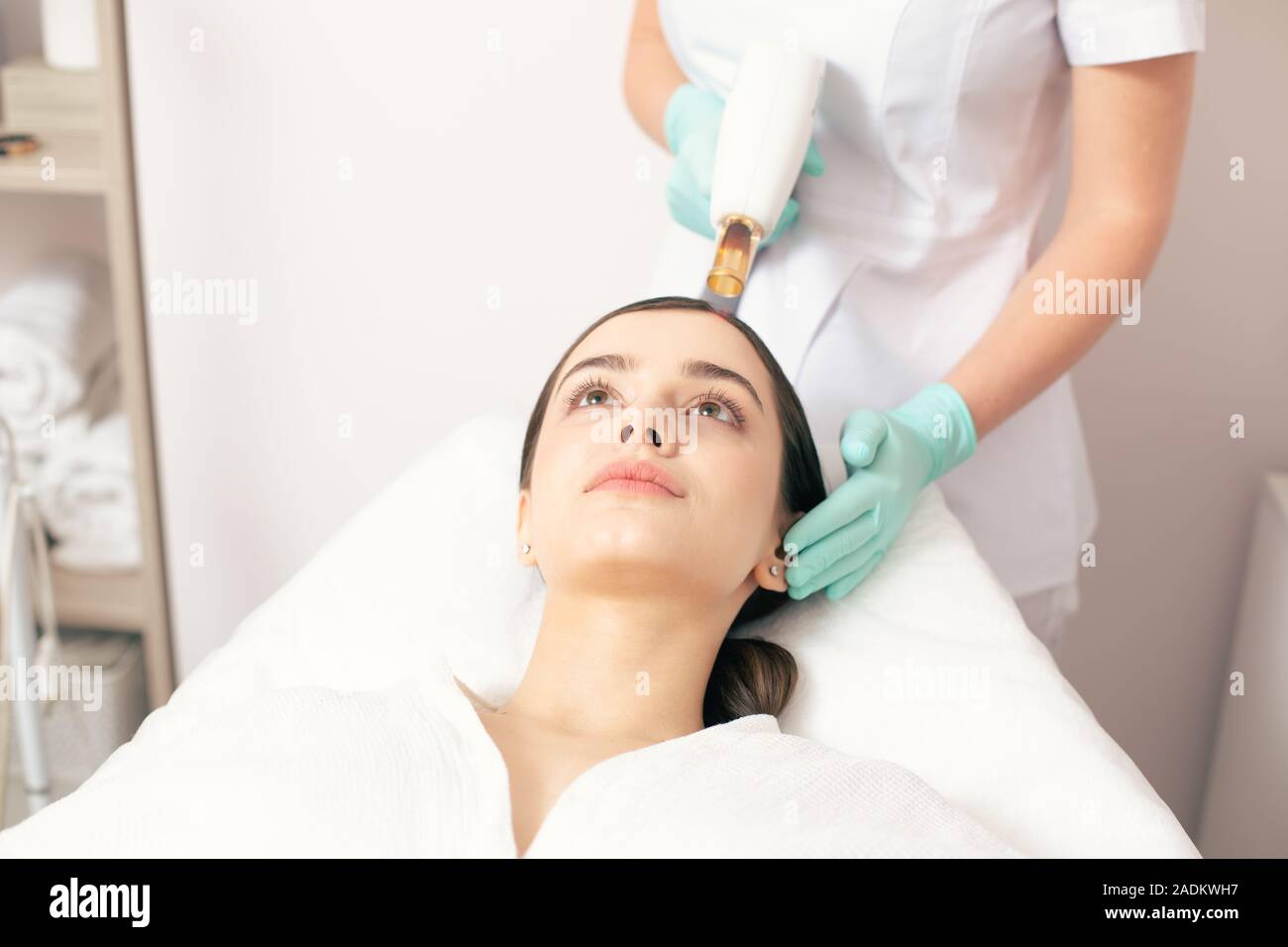 Face of young woman and medical worker using laser tool Stock Photo Alamy