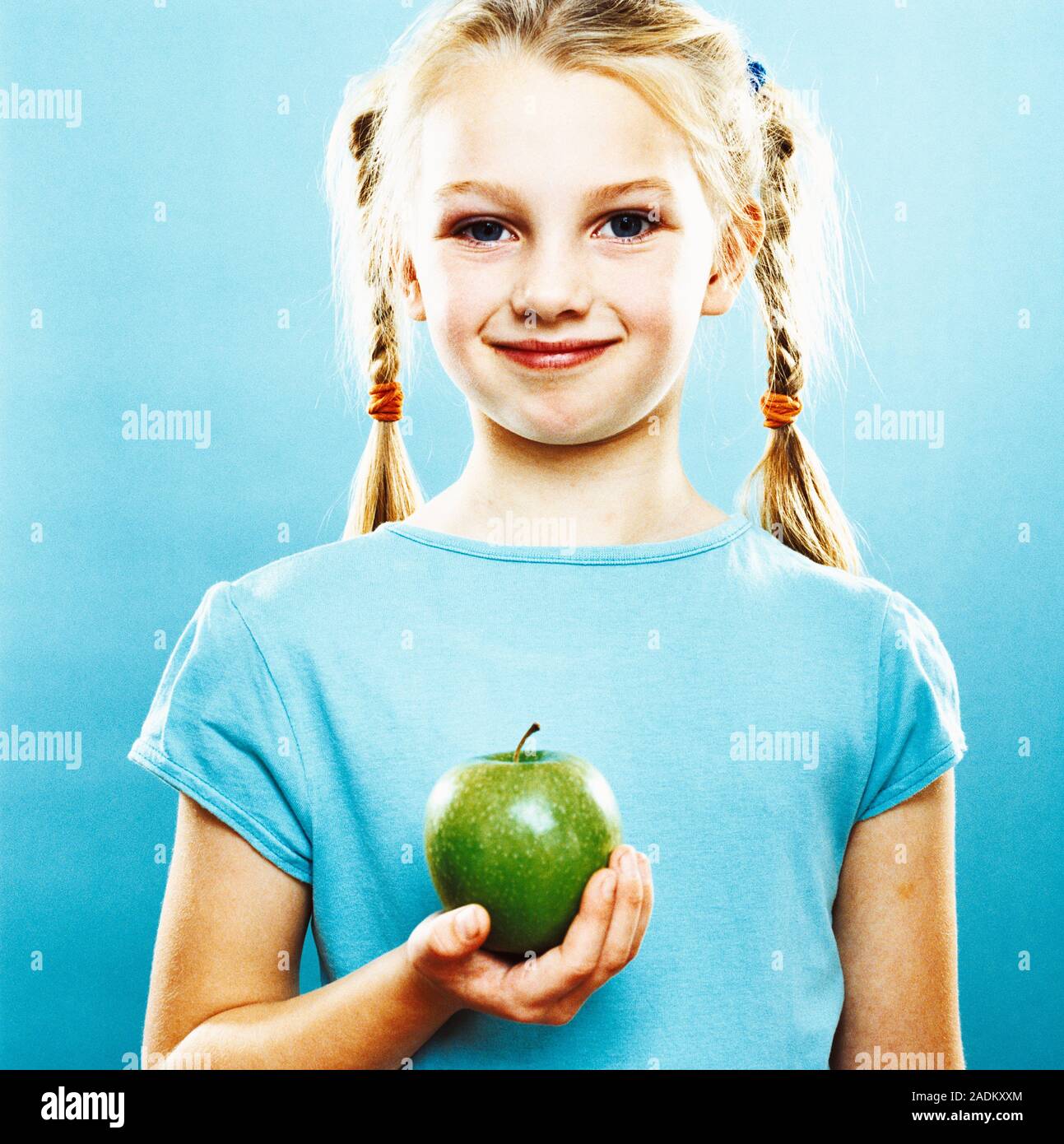 Girl holding an apple. She is seven years old Stock Photo - Alamy