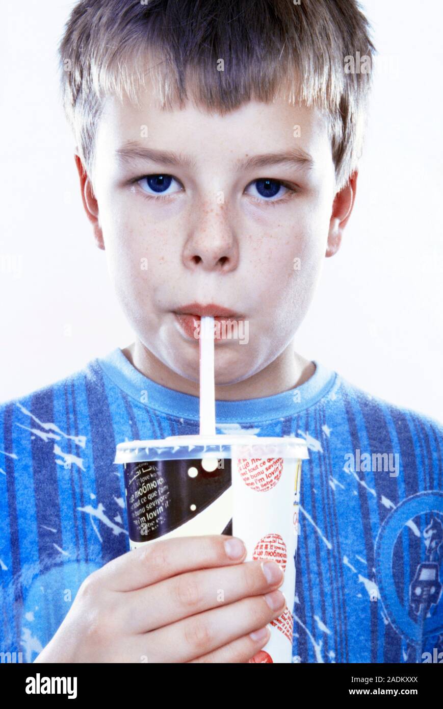 MODEL RELEASED. Boy drinking a fizzy drink through a straw Stock Photo