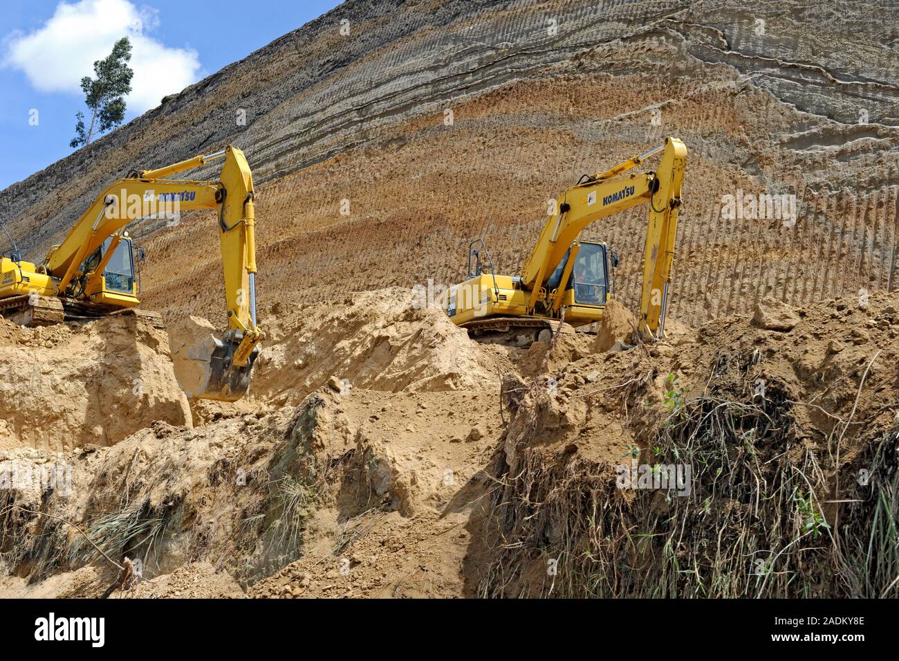 Excavators digging through volcanic deposits, making a roadway for a future highway near Quito Ecuador Stock Photo