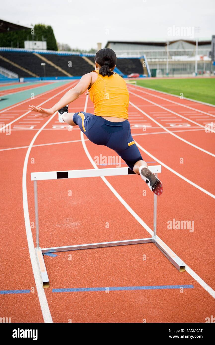 MODEL RELEASED. Athlete clearing a hurdle. Stock Photo