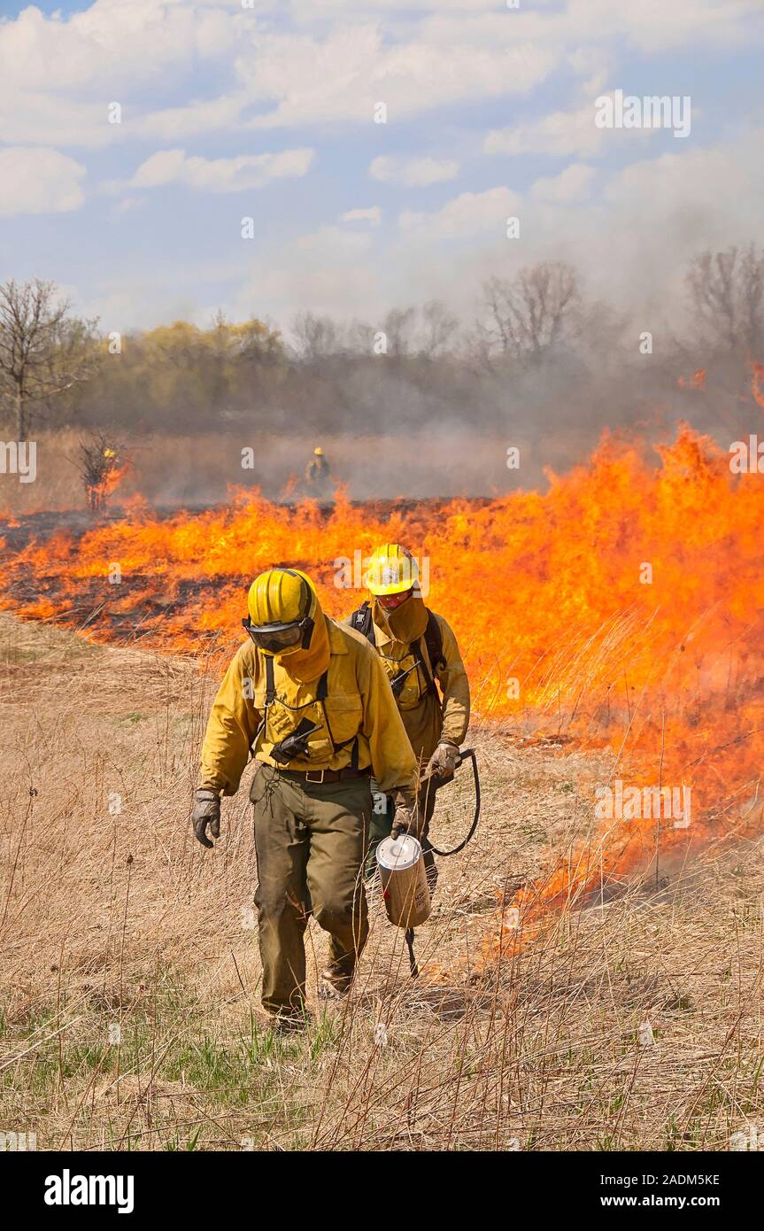 Prairie fire: Two workers on a fire crew with lead worker using a drip