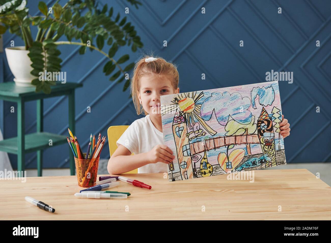 Nice interior in the room. Cute little girl in art school shows her