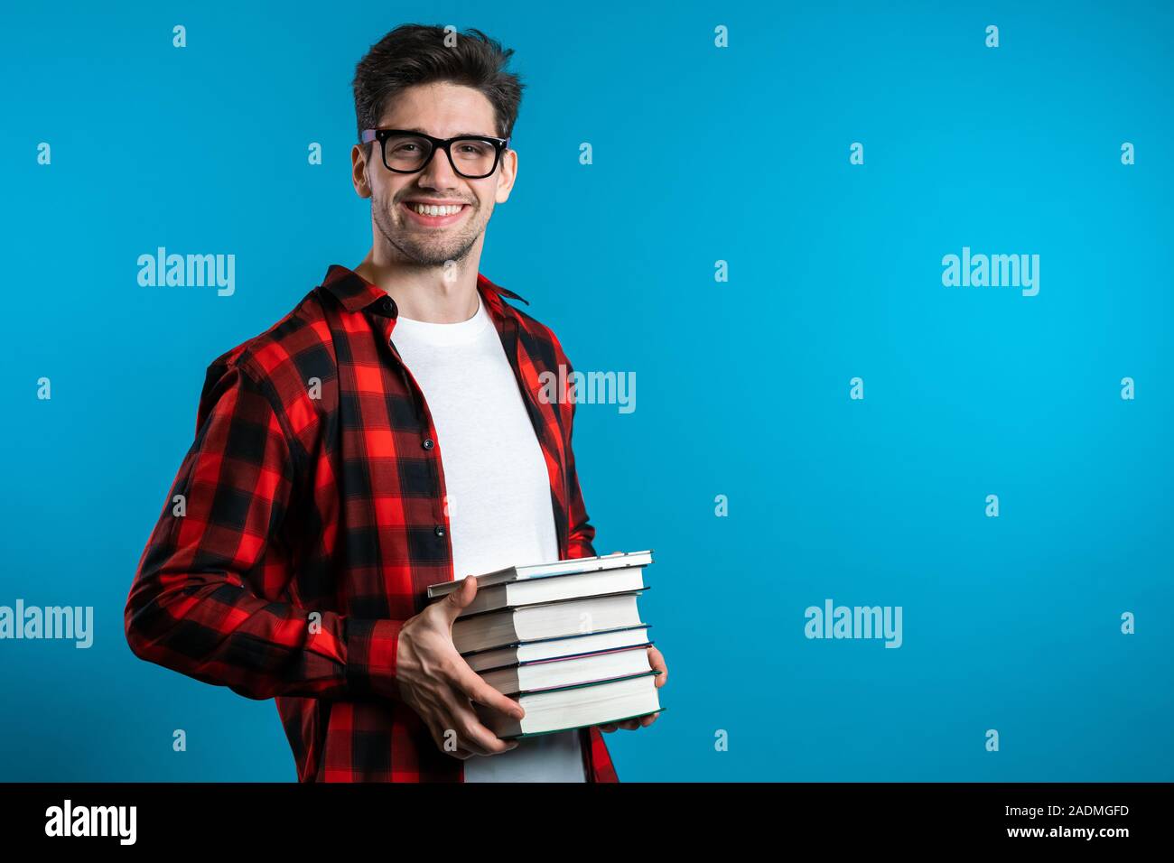 He a student now. He a student now. Group of teenage students. человек держит книгу на синем фоне. улыбчивая студент.