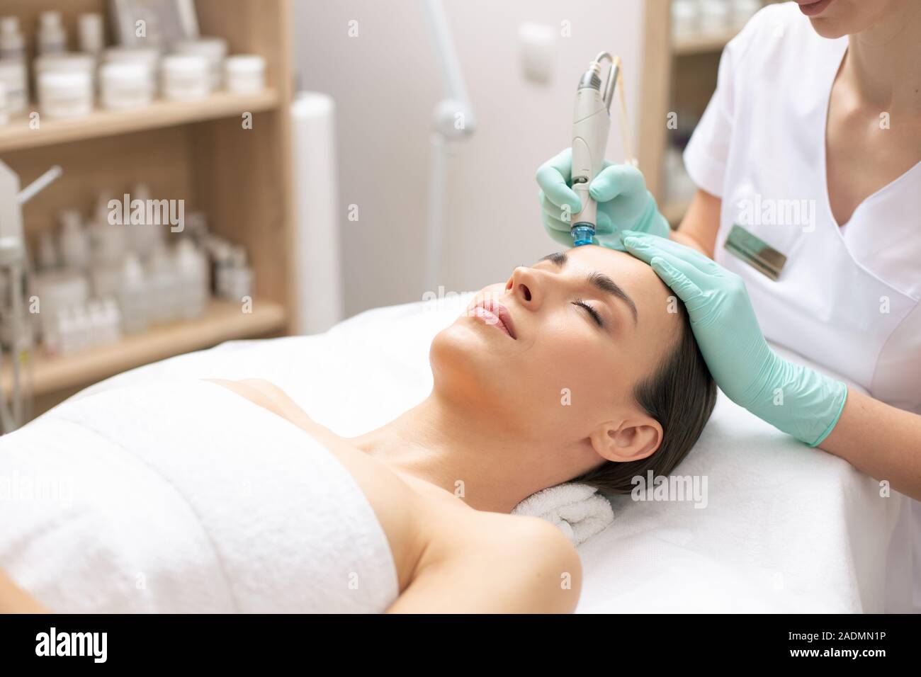 Woman lying with closed eyes at the skin cleaning procedure Stock Photo