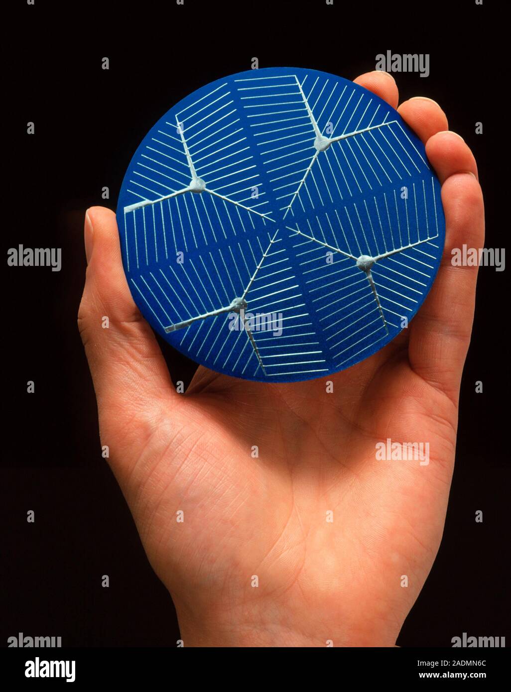 Solar cell. Hand holding a circular photovoltaic or solar cell