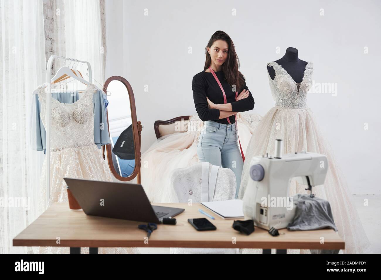 Nice day in clean room with proud owner. Female fashion designer works on the new clothes in the workshop Stock Photo