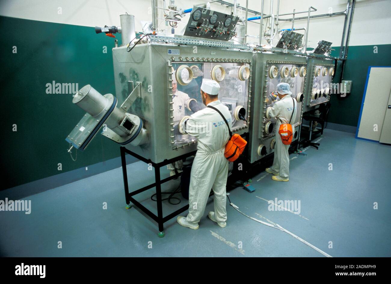 Lowlevel nuclear waste. Workers using glove boxes to sort equipment