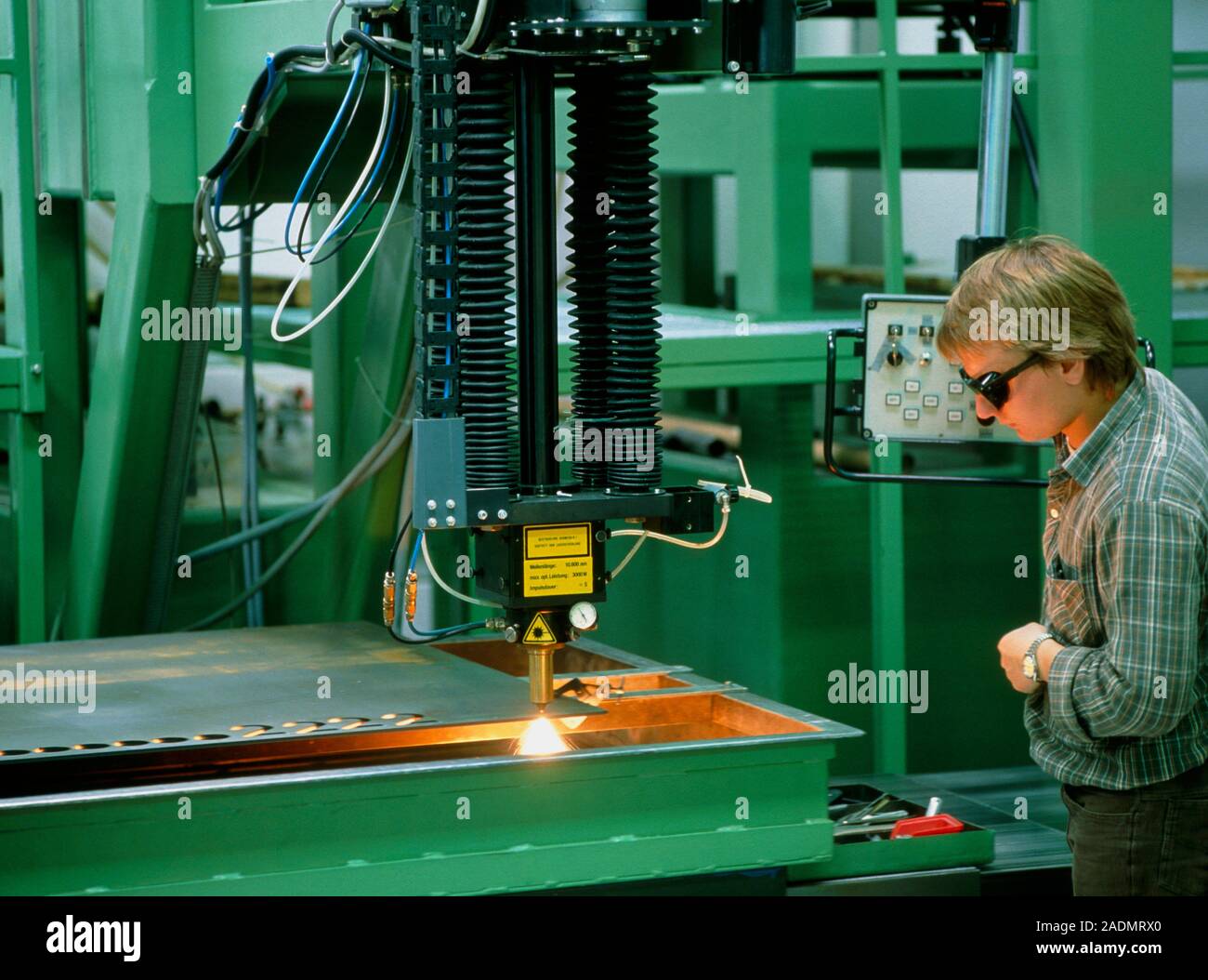 Laser cutting. Operator wearing safety glasses observes a carbon