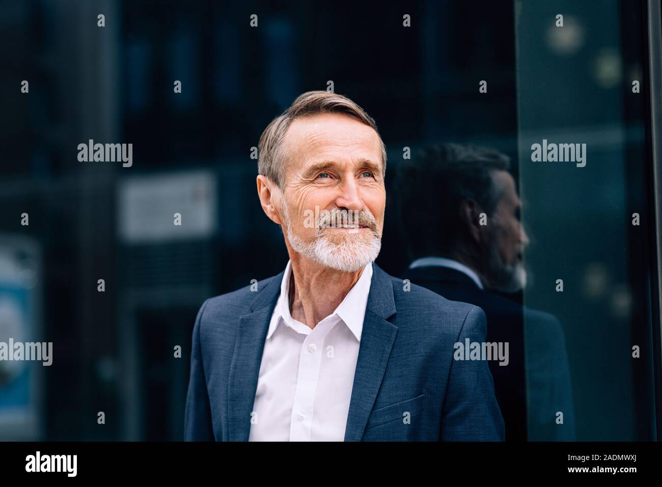 Bearded man wearing suit standing at office building outdoors Stock Photo