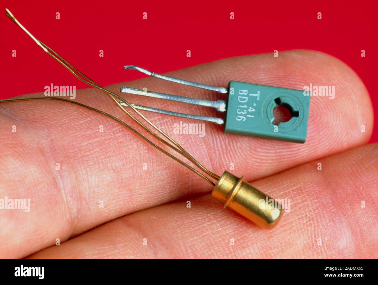 Transistors. Fingers hold transistors from the 1970s (upper) and 1960s