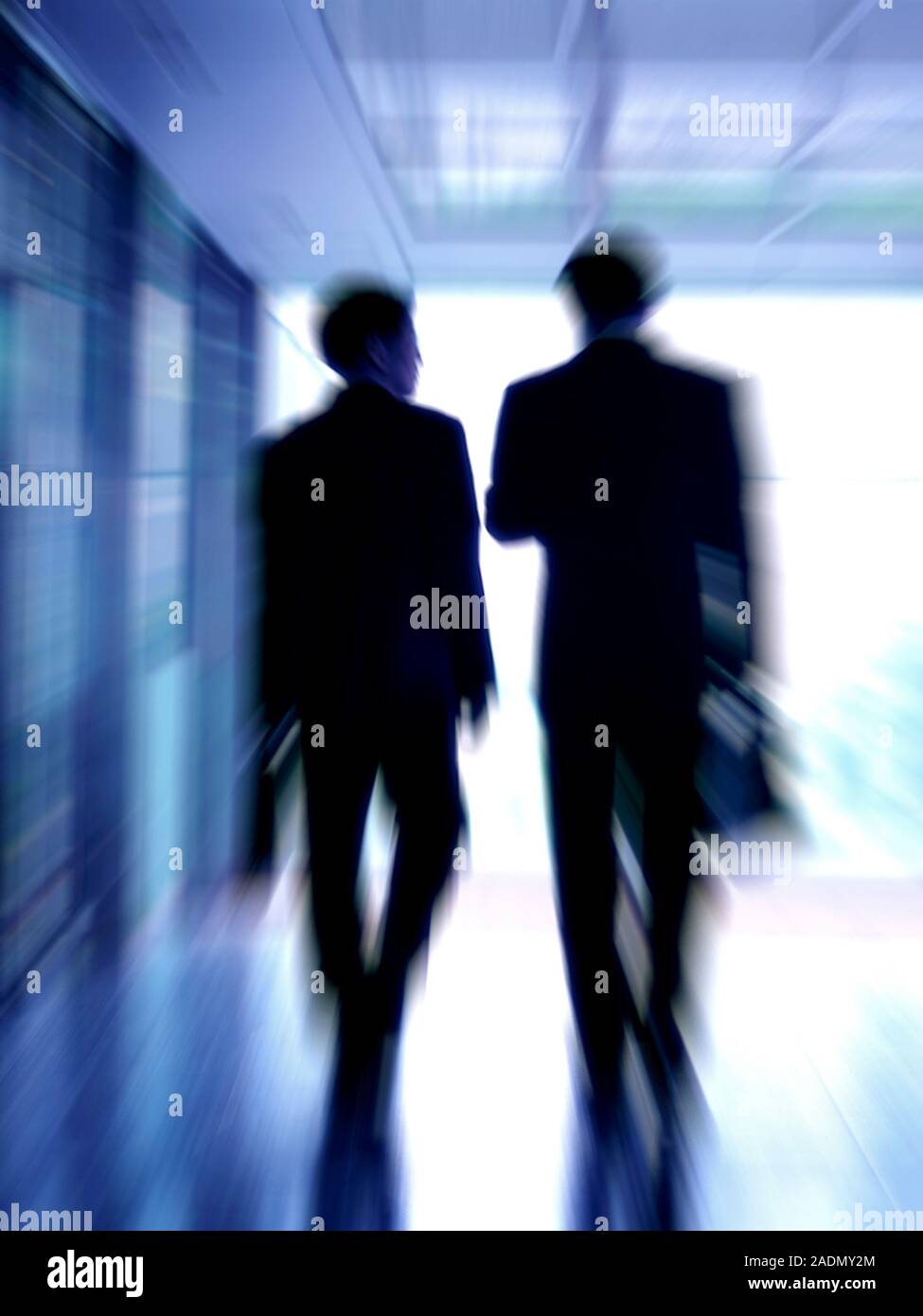 Businessmen having a discussion while walking down a corridor. Stock Photo