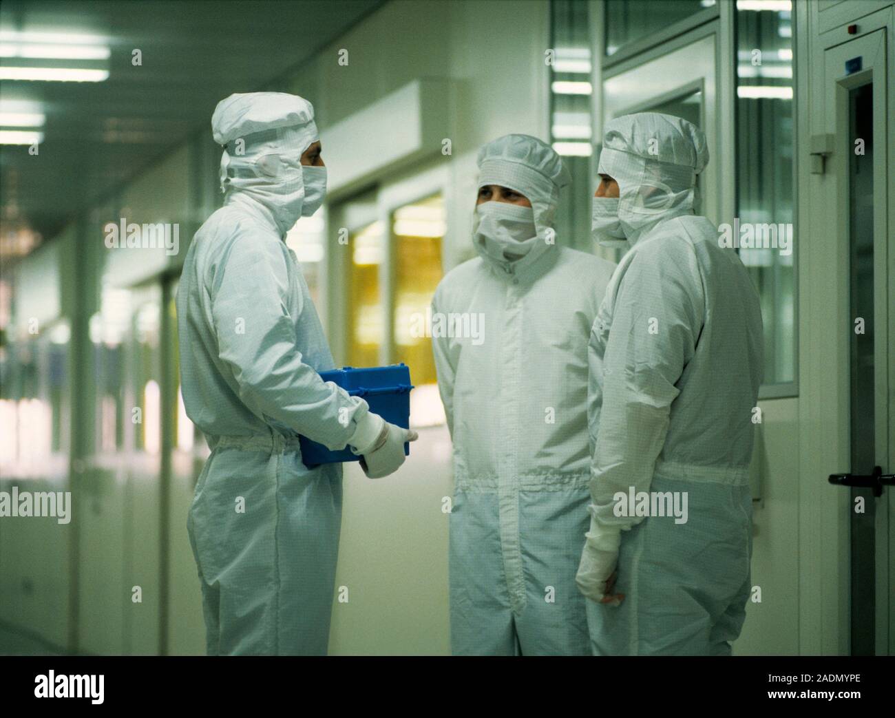 Semiconductor manufacture. Technicians at a clean room facility for
