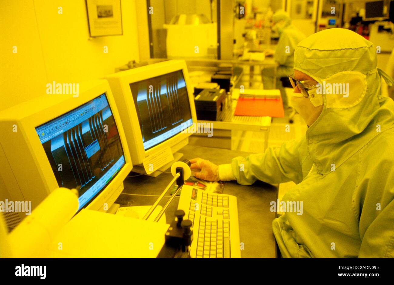 MEMS production. Clean room technician examining a computer display as