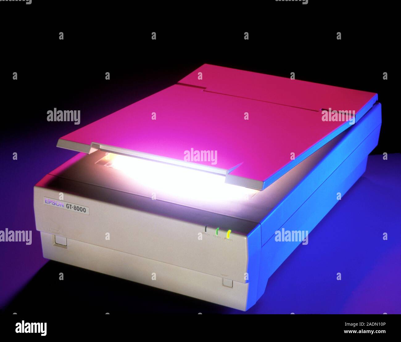 Desktop flatbed scanner with its lid partially open. A light source is