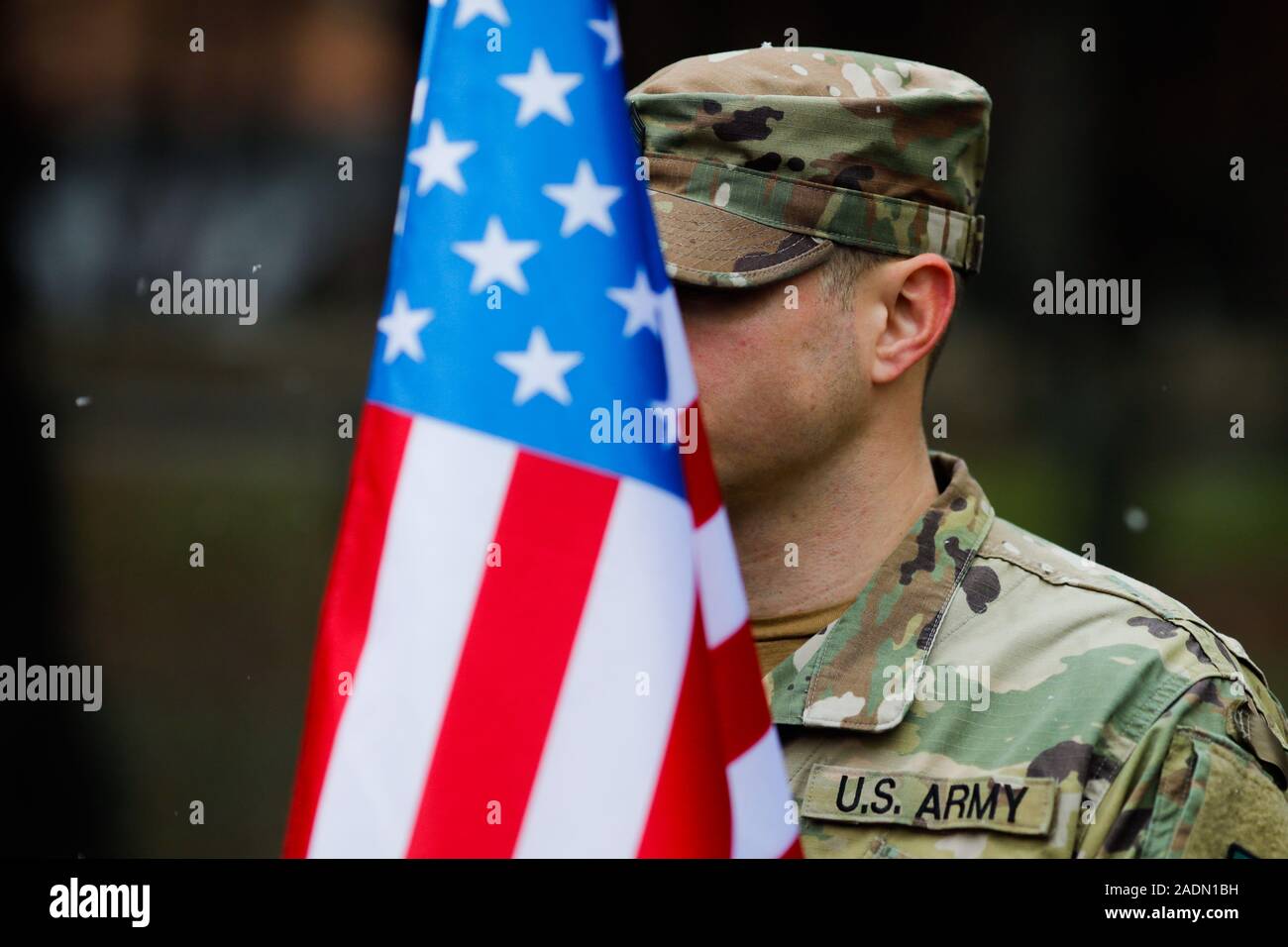 Shallow depth of field image (selective focus) with details of a US army soldier holding a flag and having MNDSE (Multi-National Division South-East) Stock Photo
