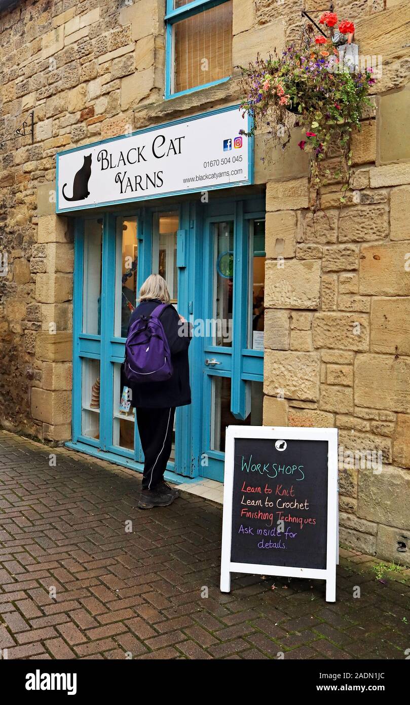 A shopper, possible customer, is about to enter the Black Cat Yarn wool and yarn shop in Morpeth in Northumberland. Stock Photo