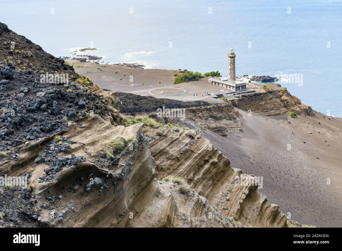 View from above the lighthouse at the westernmost point of Europe with volcanic geology in the foreground leading down to the ocean. Stock Photo