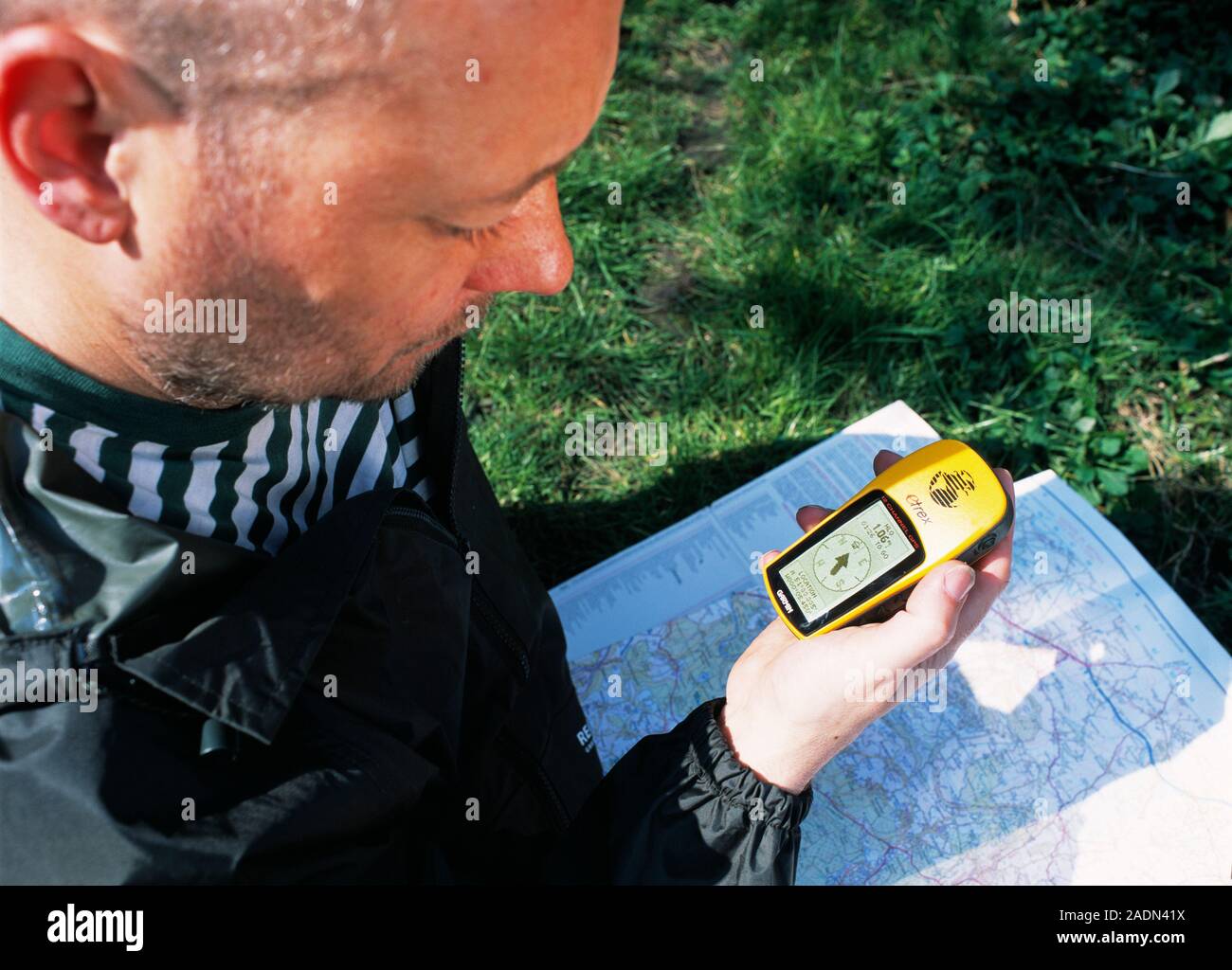 Global positioning system (GPS). Man using a handheld GPS receiver and