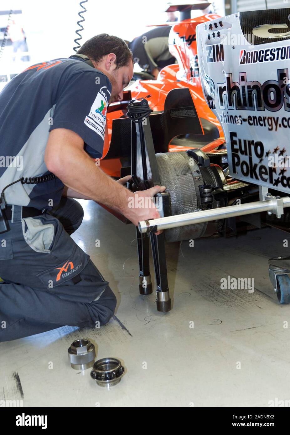 MODEL RELEASED. Formula One car preparation. Mechanic adjusting the