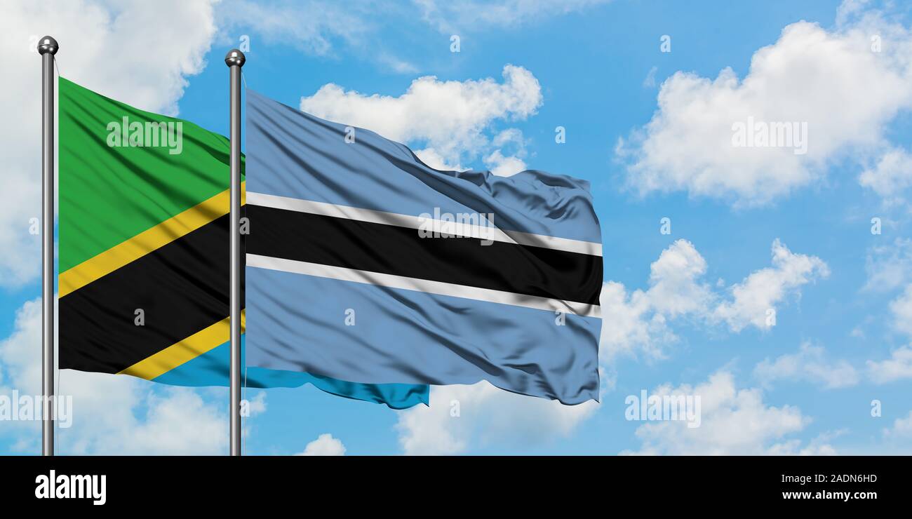 Tanzania and Botswana flag waving in the wind against white cloudy blue ...