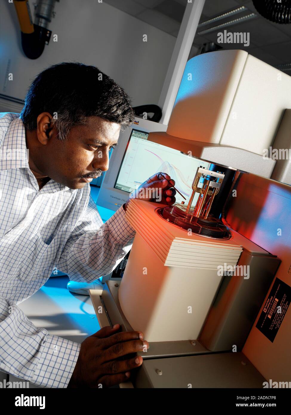 Dynamic mechanical analysis. Physicist adjusting a dynamic mechanical