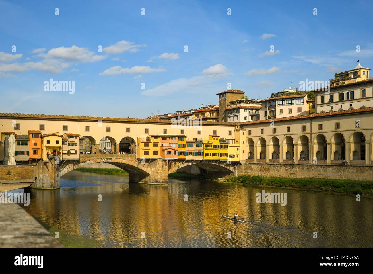View of the famous Ponte Vecchio bridge in the historic centre of Florence, Unesco World Heritage Site, with a man rowing a canoe, Tuscany, Italy Stock Photo