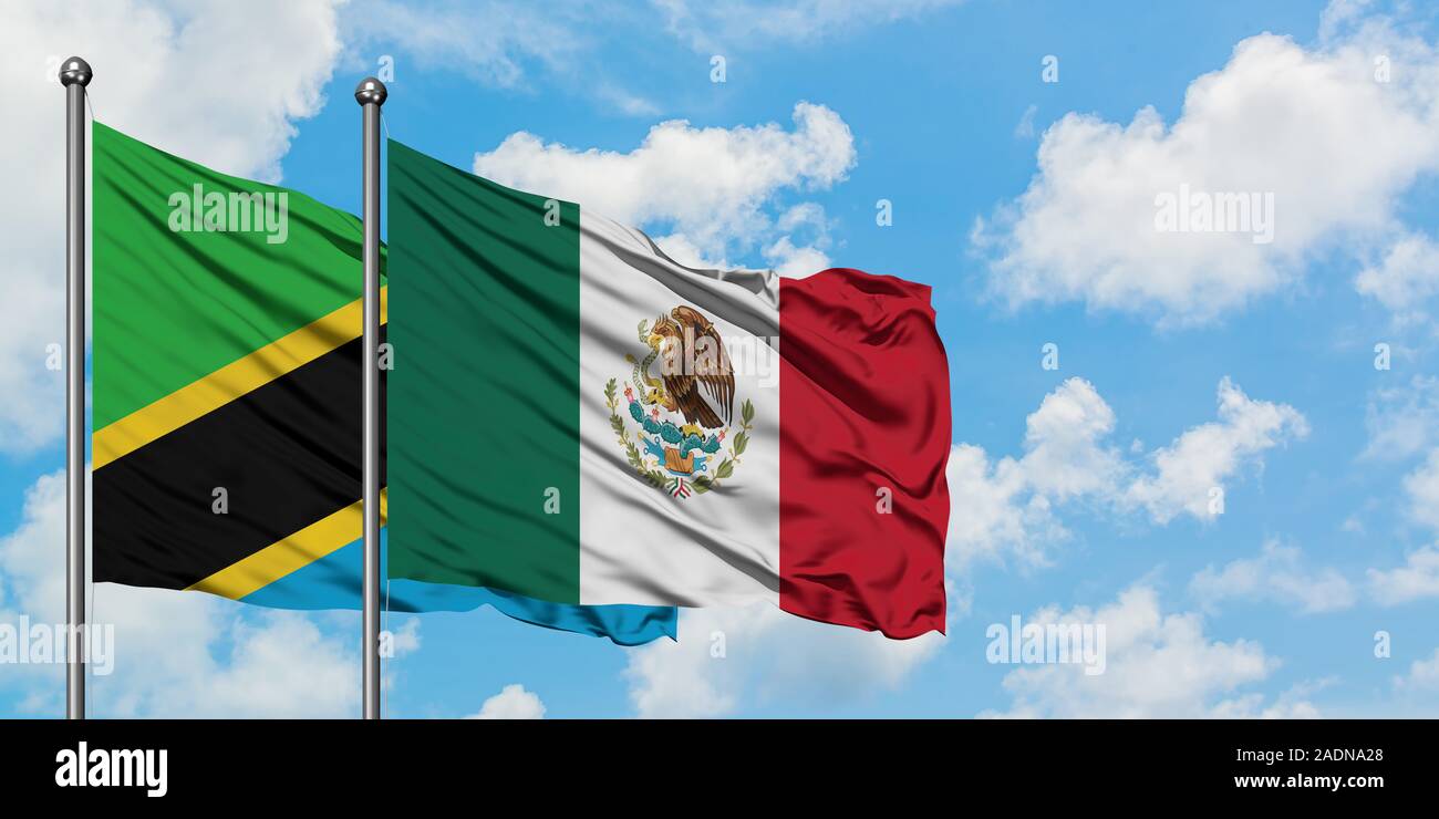 Tanzania and Mexico flag waving in the wind against white cloudy blue ...