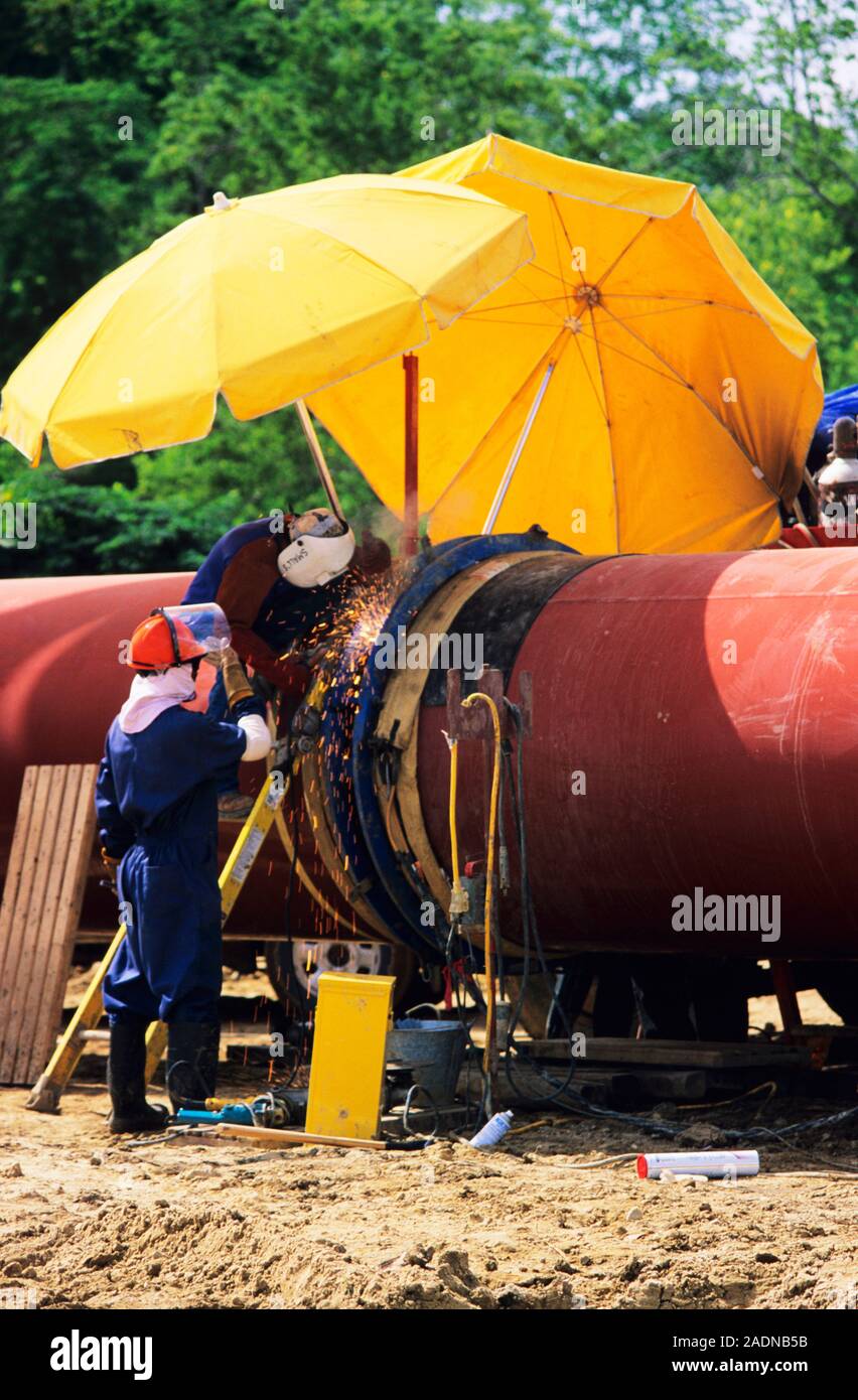 Gas line construction. Workers welding two pipes together during the construction of a gas line