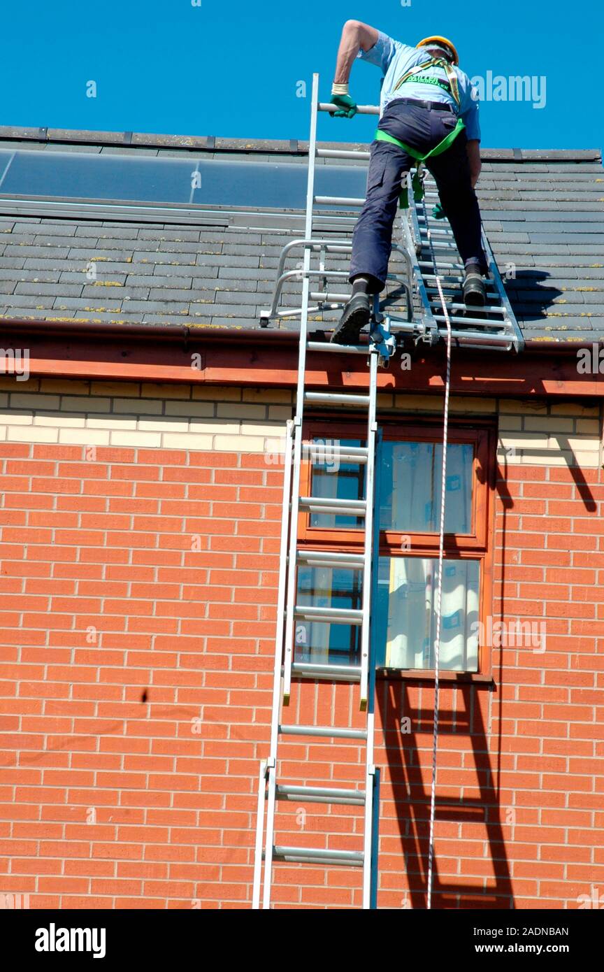 Rooftop safety harness. Worker on the roof of a building using
