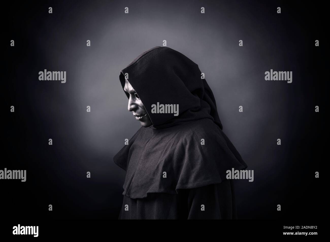 Scary figure in hooded cloak with mask Stock Photo - Alamy