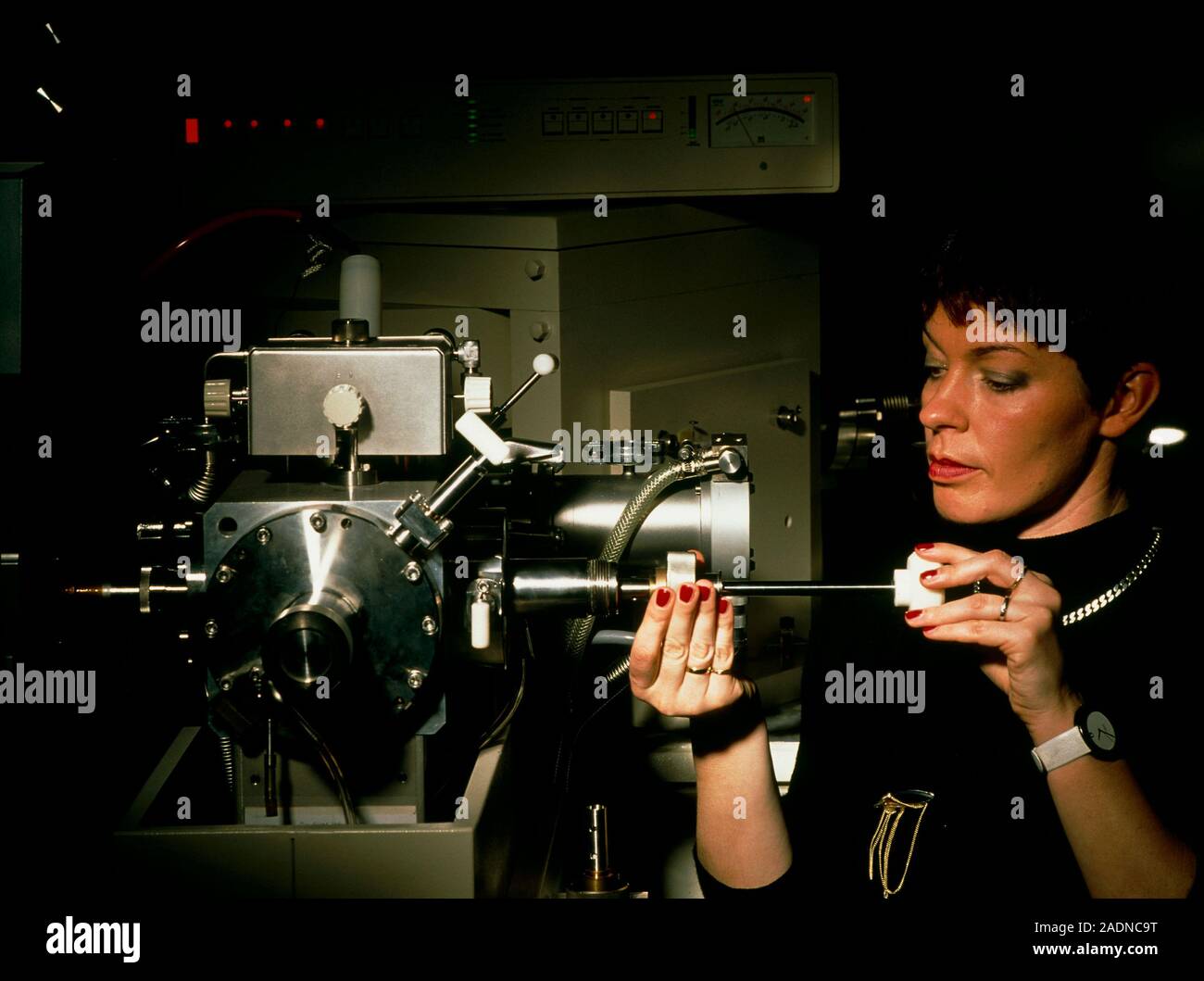 Mass Spectrometry. Female technician loading a sample into a mass