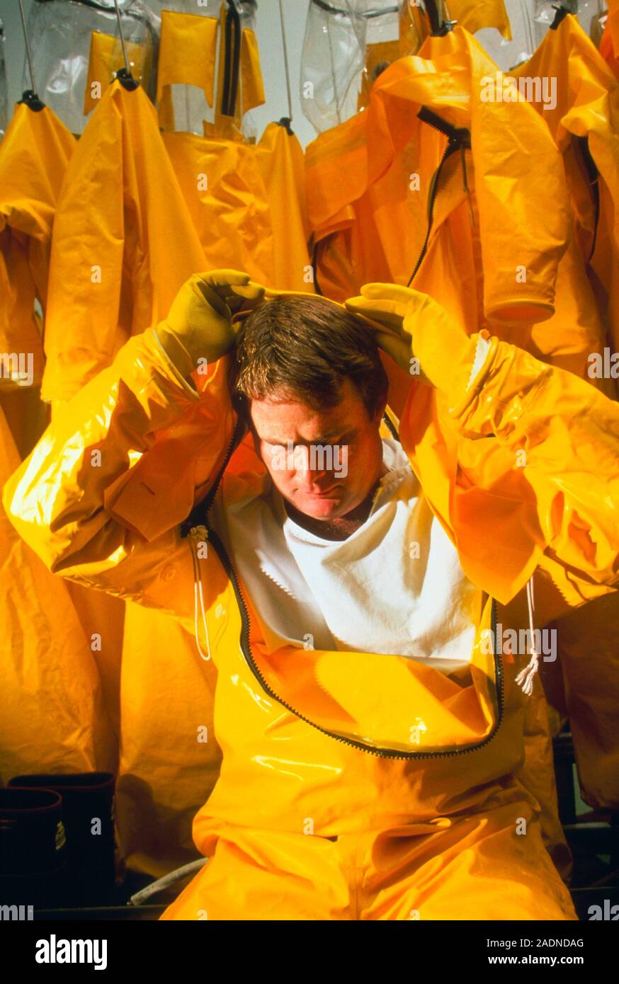 Pharmaceutical suit. Male technician putting on a protective bubble