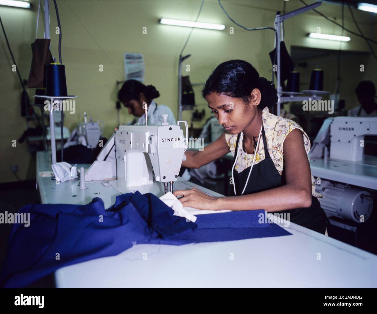 Clothing manufacture. Woman sewing clothes in a factory. Photographed ...