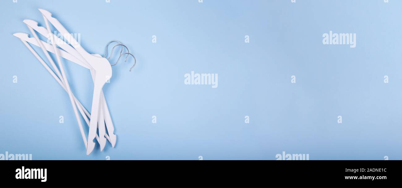 White wooden clothes hanger on blue background. Banner. Fashion concept Stock Photo