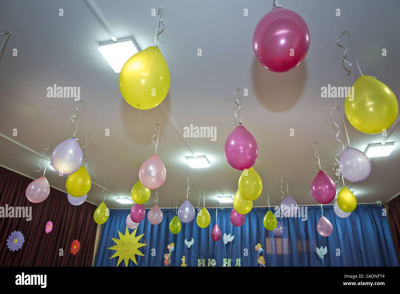 Pink And Yellow Balloons Float On The White Ceiling In The