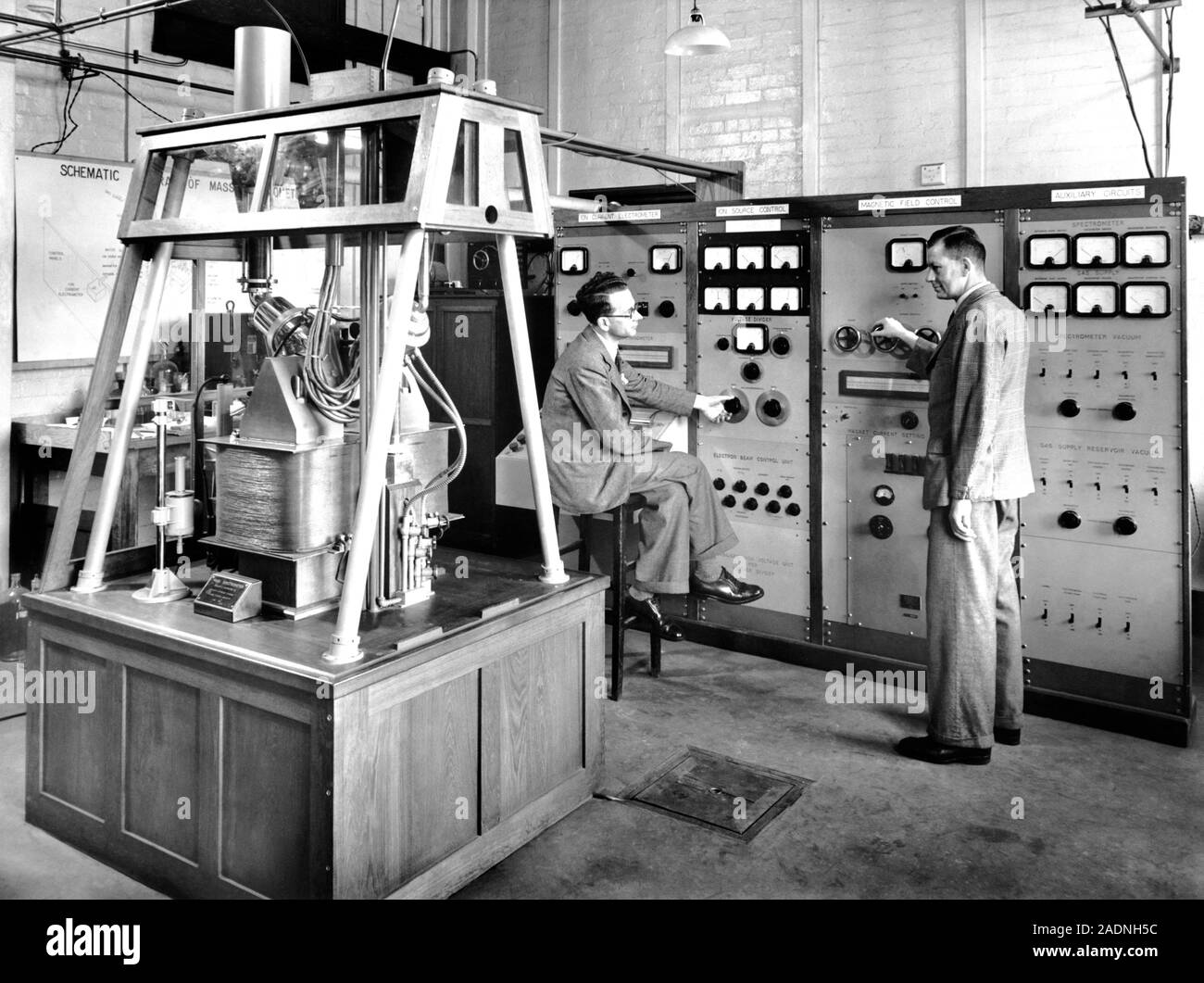 Mass spectrometer. Researchers adjusting the controls of a mass