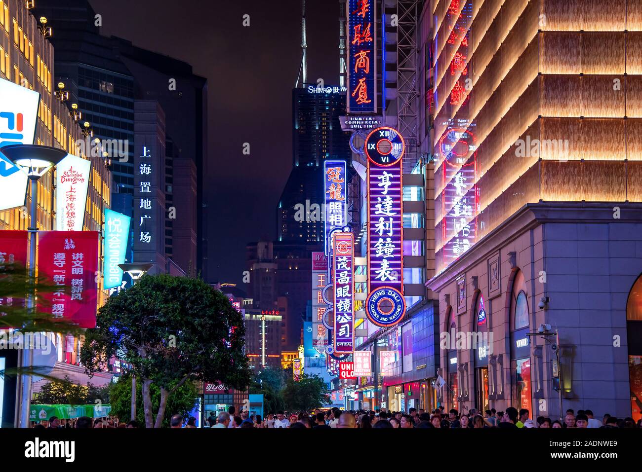 Shanghai, China - August 7, 2019: Nanjing road in downtown Shanghai with neon signs and shops and tourists walking around at night Stock Photo