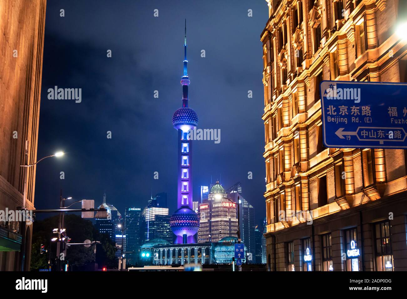 Shanghai, China - August 7, 2019: Oriental Pearl TV Tower rising above downtown road in downtown area of Shanghai at night Stock Photo