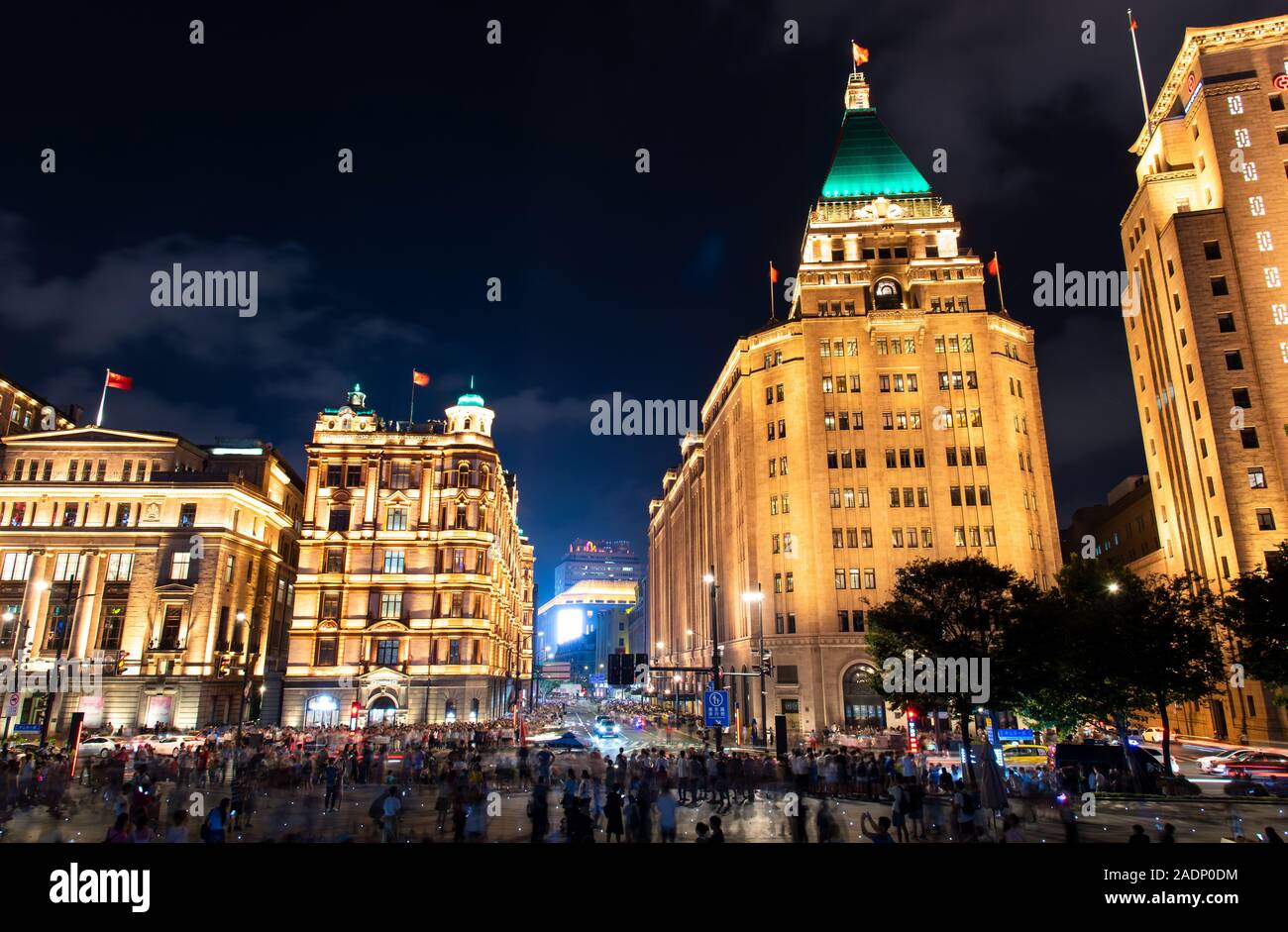 Shanghai, China - August 7, 2019: Busy streets of Shanghai with modern and traditional architecture and tourists walking to the Bund scenic viewpoint Stock Photo