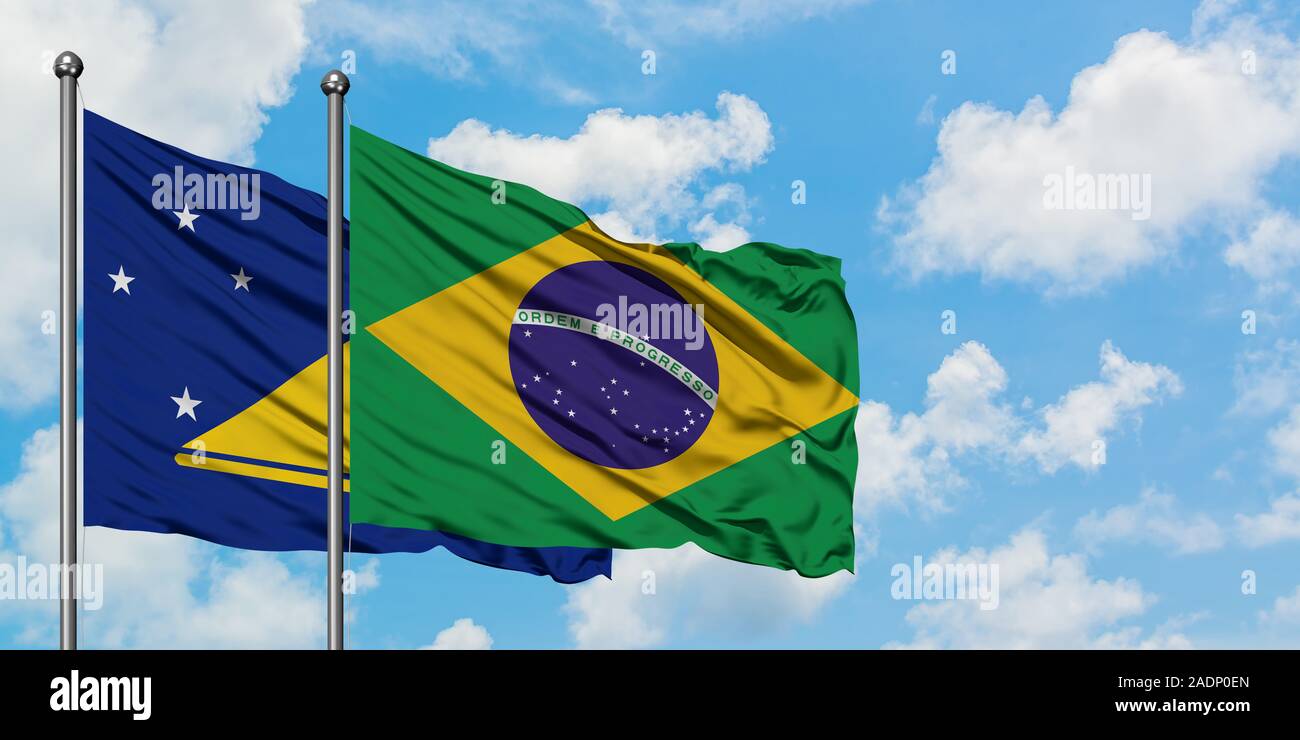 Tokelau and Brazil flag waving in the wind against white cloudy blue ...