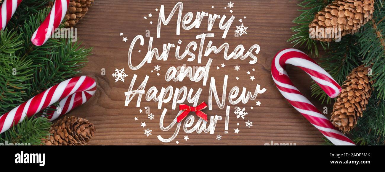 Christmas Card With Wishes Words In English Merry Christmas And A Happy New Year Christmas Tree Branch Decorated With Garlands Cones And Caramel St Stock Photo Alamy