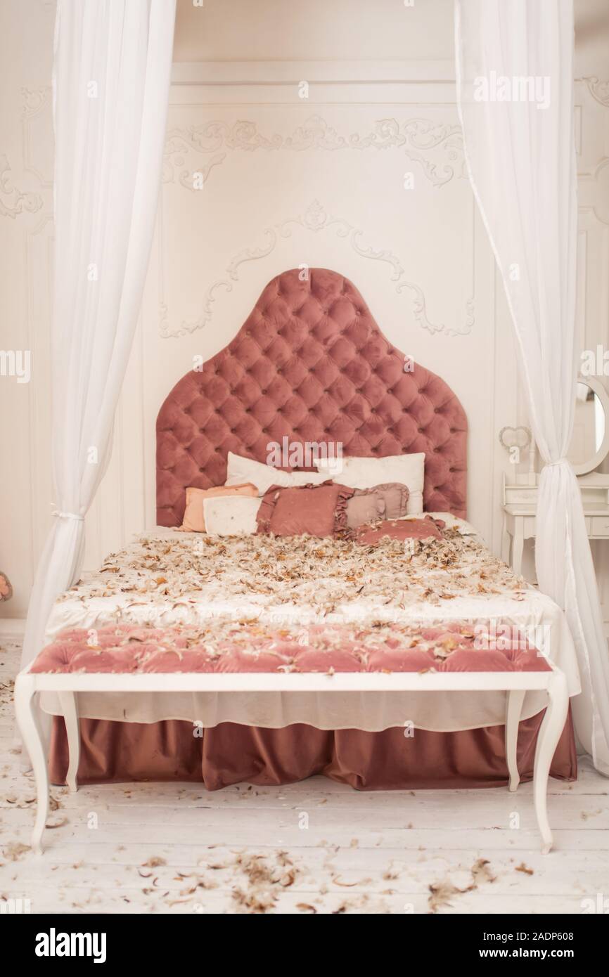 Chic Retro King Size Bed Strewn With Feathers From The Pillow