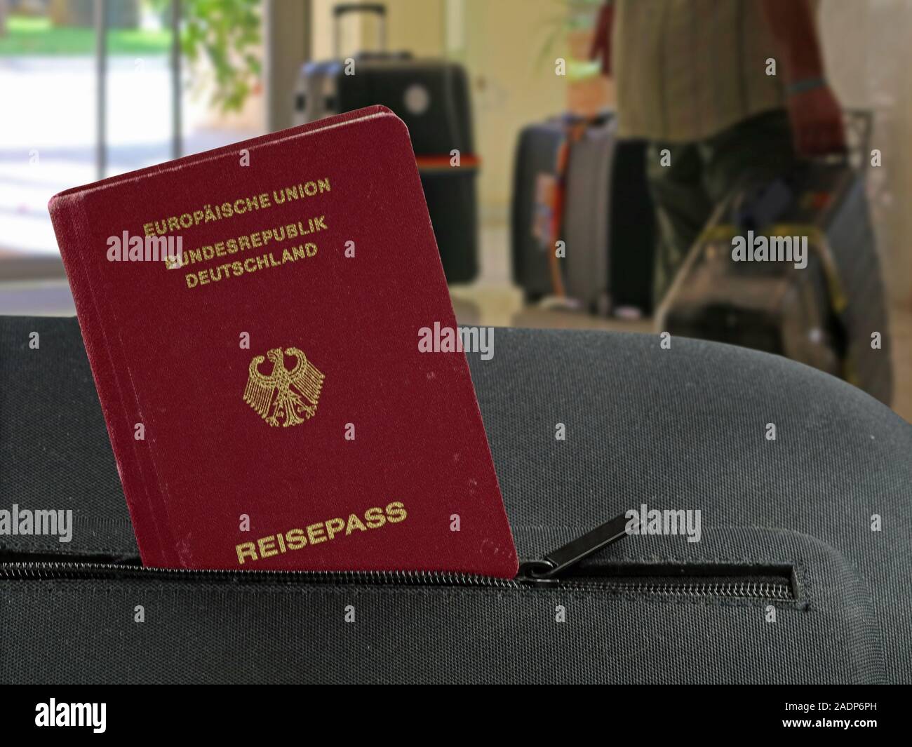 german passport in a pocket of a black suitcase with hotel lobby on background Stock Photo