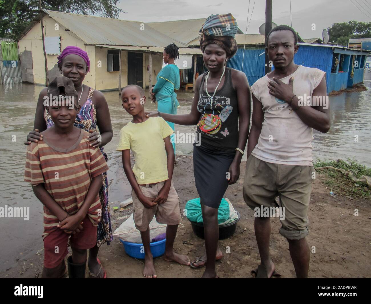 Akwero Beatrice, her sister Alaker and their children victims of the flood pose for a pic.Businesses and homes damaged by flooding in Elegu, northern Uganda, on the border with South Sudan. Thousands of people across East Africa are currently affected by flooding. Stock Photo