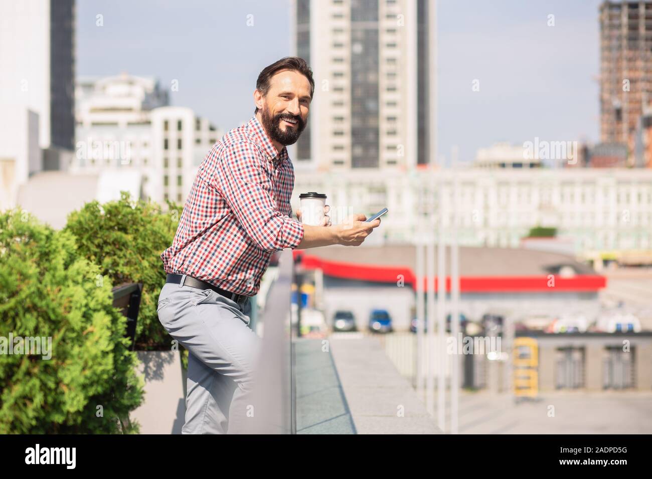 Cheerful adult man standing on the rooftop Stock Photo