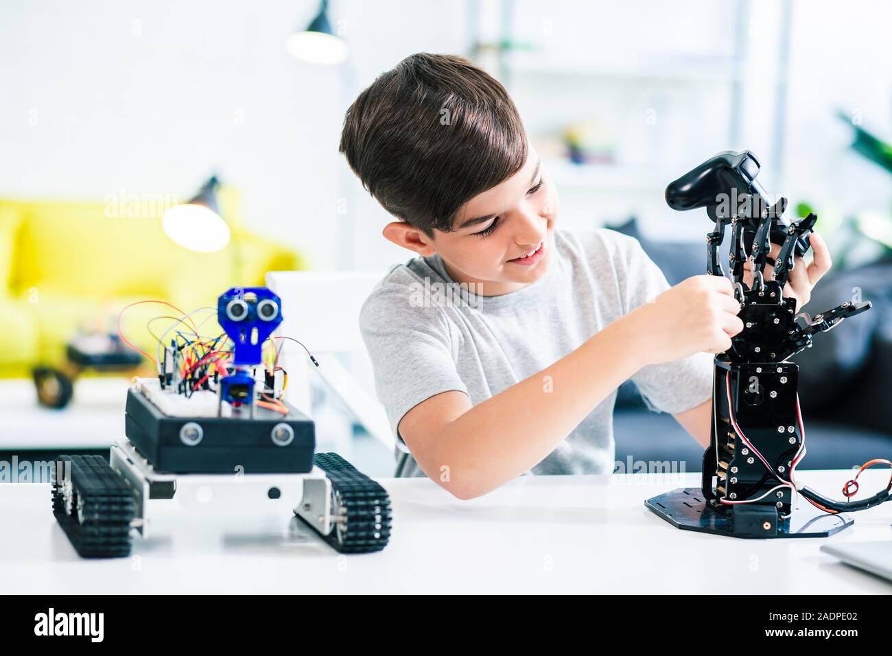 Cheerful schoolboy making experiments with his robotic device Stock Photo