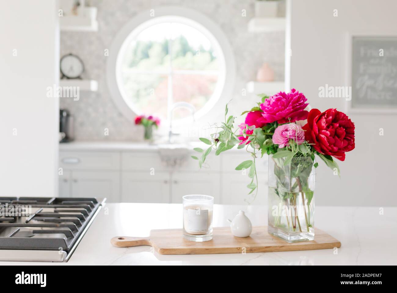Flowers in a white kitchen  with candle Stock Photo